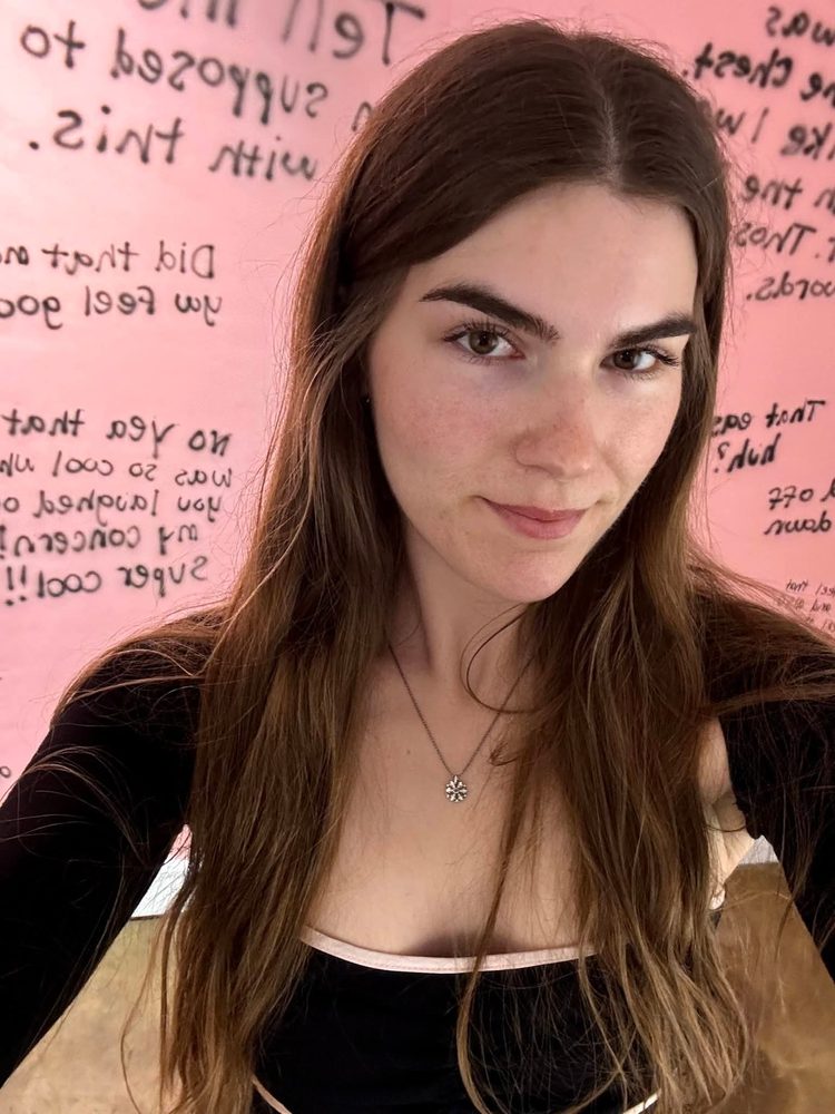 Grace now, an everyday selfie in front of a pink wall